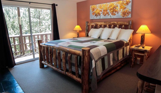 Suite features King bed, full kitchen, and deck with a river view.